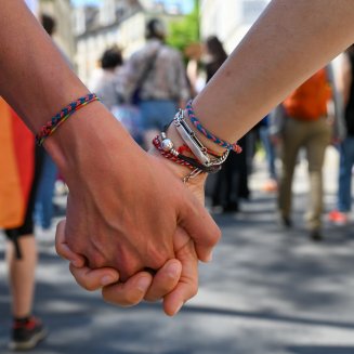 Deux personnes se tenant la main pendant la marche des fiertés 2023