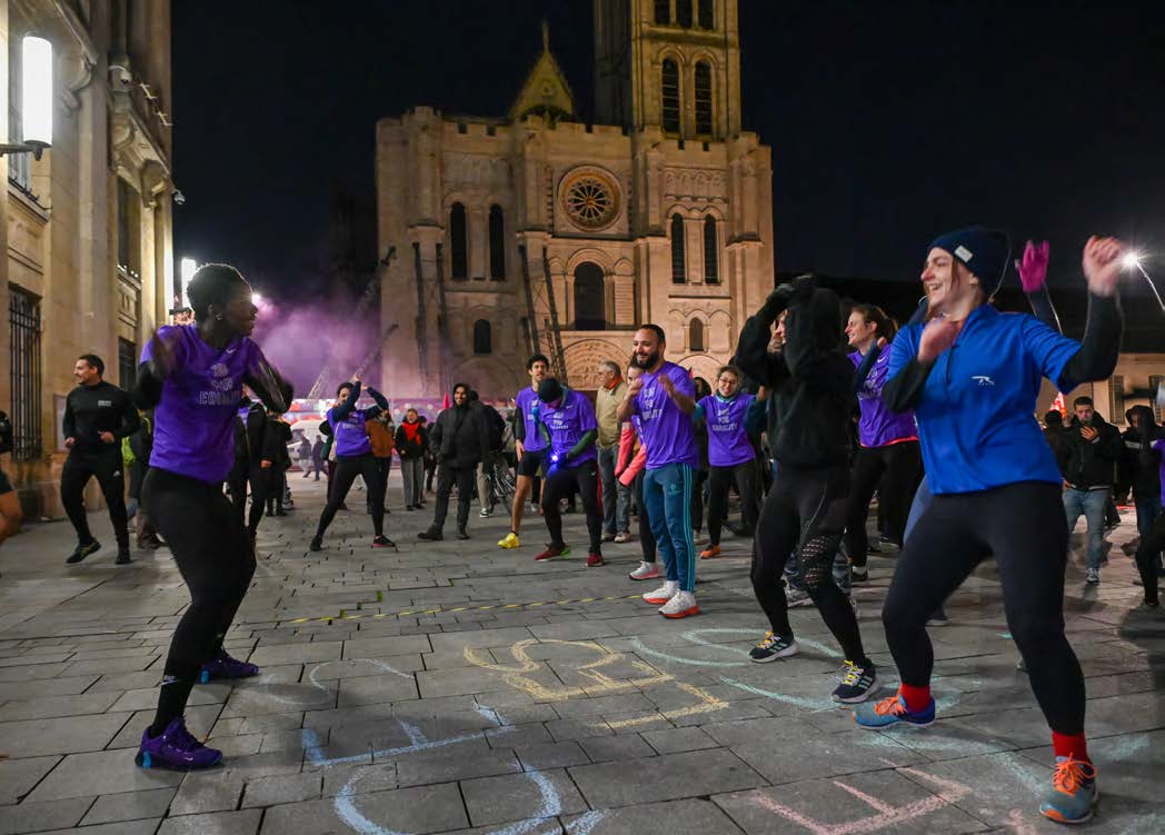hommes et femmes faisant du sport de nuit devant la Basilique de Saint-Denis